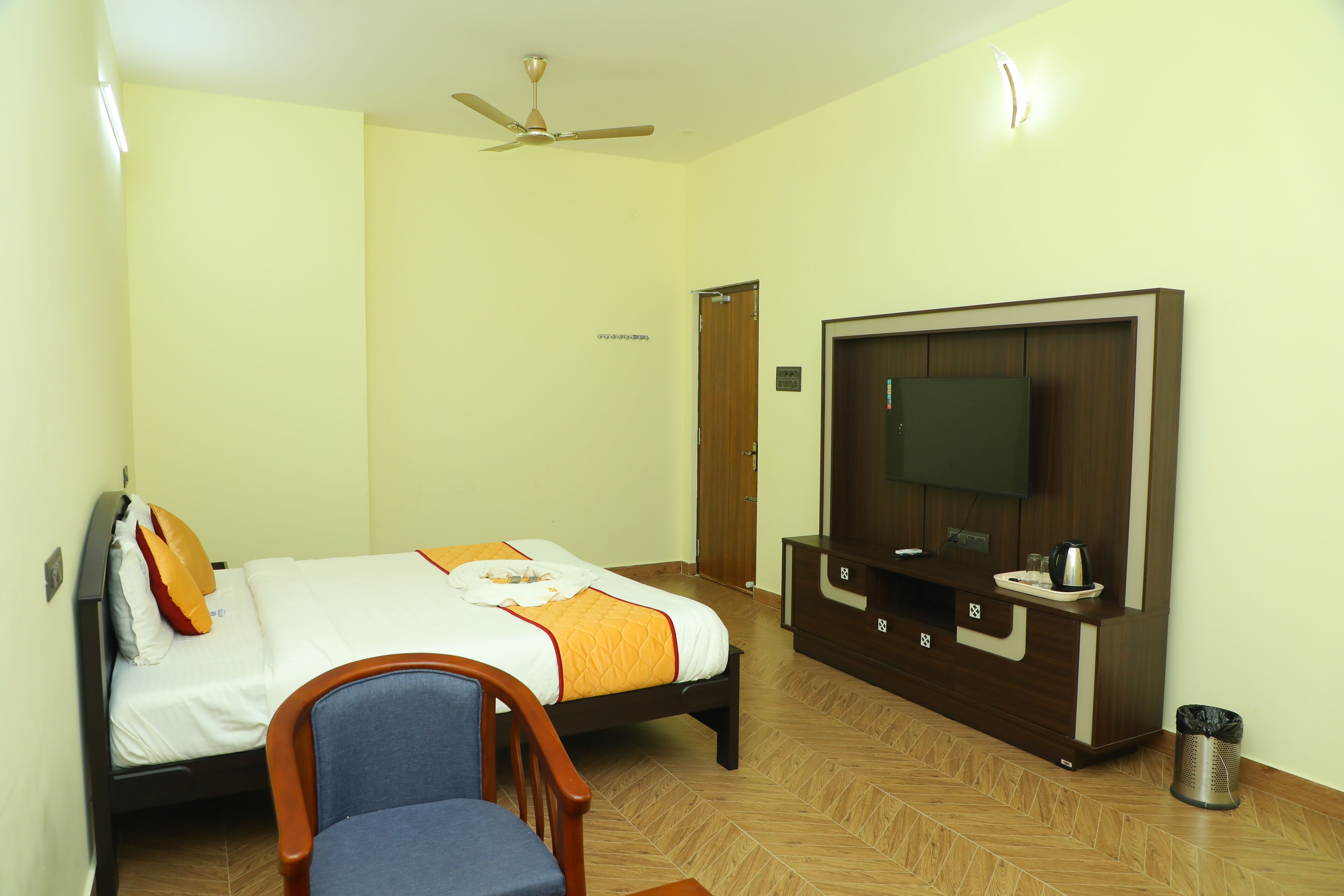 Una habitación de hotel con una cama, televisión, escritorio y una silla.