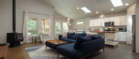 A modern living room with a sofa, ottoman, and a fireplace.