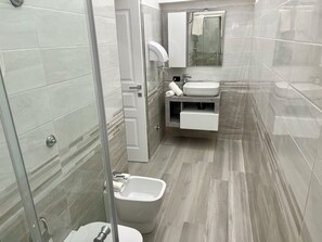 Chuveiro, secador de cabelo, bidê, toalhas de banho