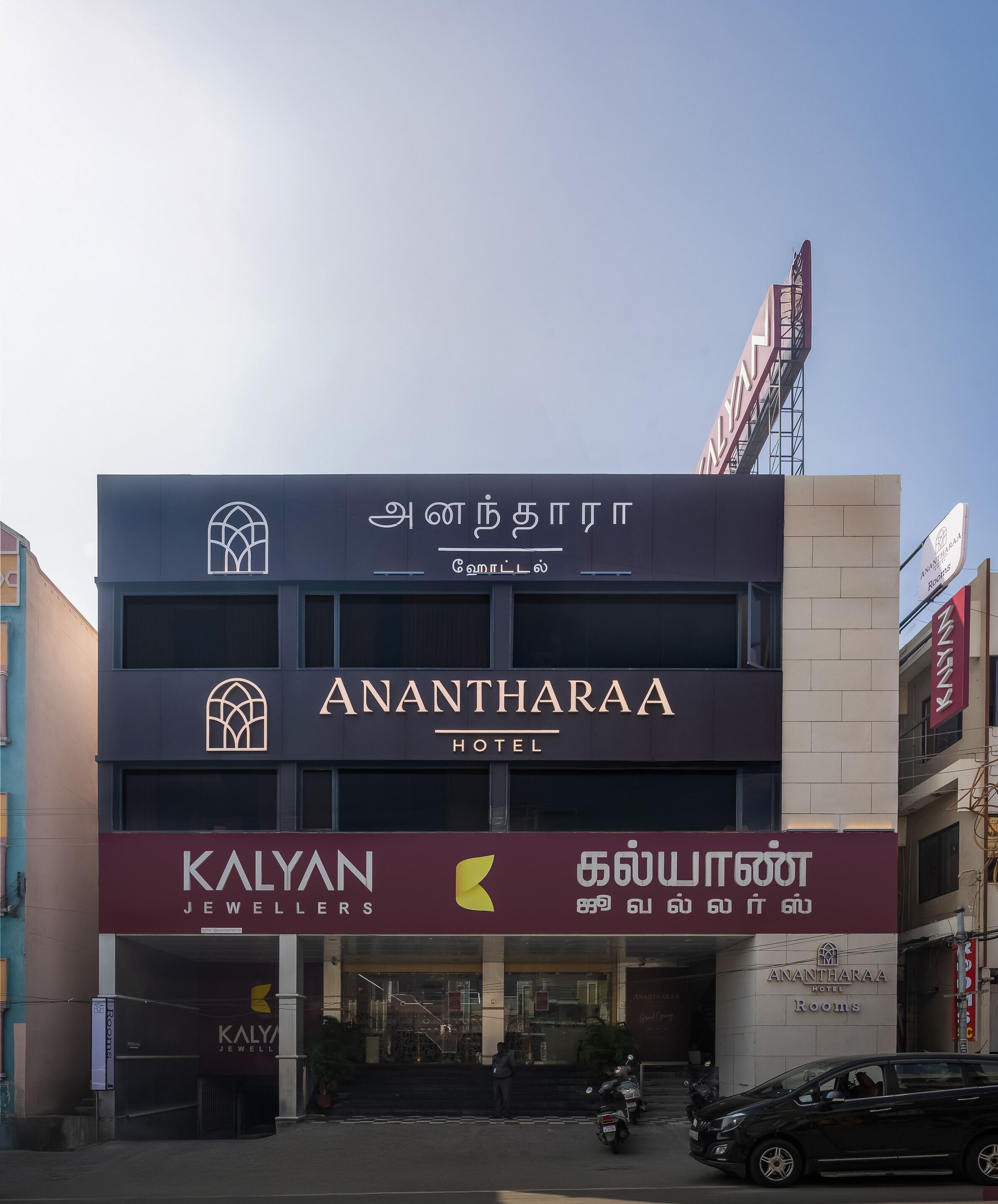 Un hôtel avec une enseigne indiquant « Anantharaa Hotel » et, en dessous, une bijouterie nommée « Kalyan Jewellers ».