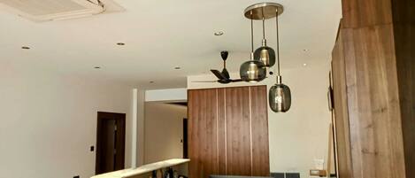 A modern reception area with a curved counter, wooden paneling, and pendant lighting.