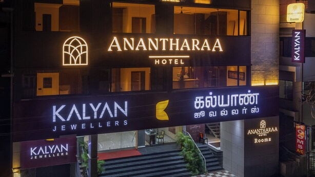 Esterno dell'hotel Anantharaya con insegne per Kalyan Jewellers e Anantharaya Rooms.
