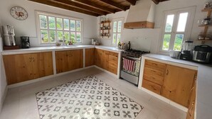 Una cocina con armarios de madera, un tapete estampado y una estufa.