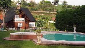 Una casa con piscina, rodeada de una valla y follaje.