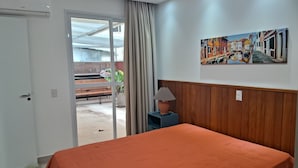 Una habitación de hotel con cama, un cuadro, una lámpara y vistas al exterior.
