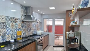 Una cocina moderna con salpicadero de azulejos, electrodomésticos de acero inoxidable y armarios de madera.