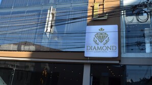Un immeuble à plusieurs étages sur lequel on peut lire l’inscription : « Diamond Luxury Hotel ».