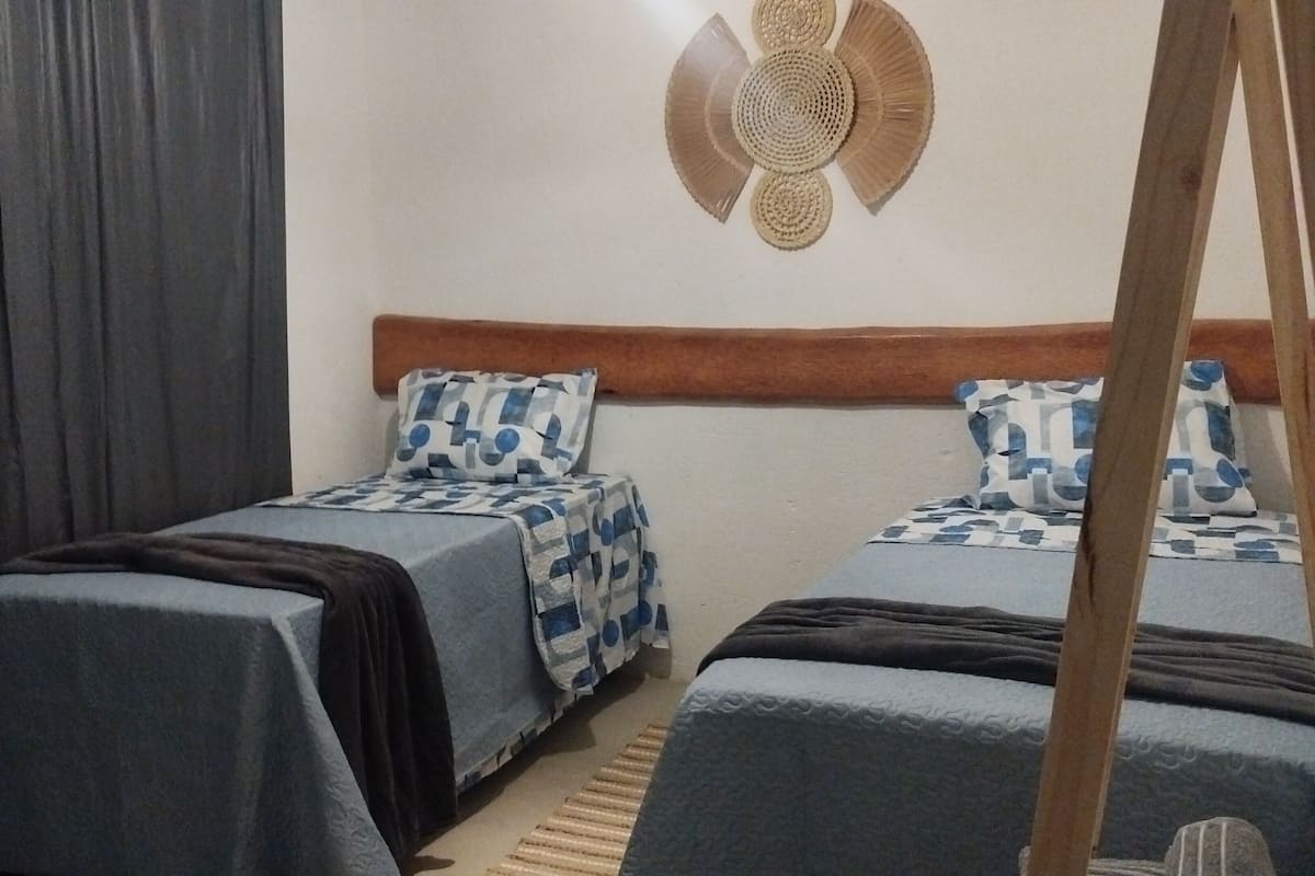 Una camera da letto con due letti, una testiera in legno e un arazzo a parete.