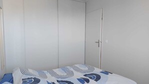 Et soveværelse med seng, skab og dør.