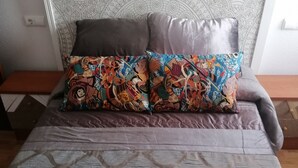A bed with patterned bedding and two decorative pillows. - 3 bedrooms penthouse in the center of Cangas de Onis (Cangas de Onís)