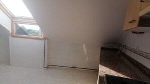 A kitchen with white tiled walls, a window, and a countertop. - 3 bedrooms penthouse in the center of Cangas de Onis (Cangas de Onís)