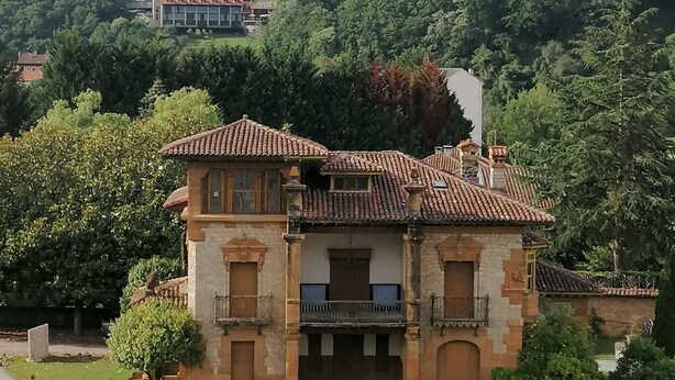 A traditional stone building with a tiled roof, surrounded by lush greenery and a hill in the background. - 3 bedrooms penthouse in the center of Cangas de Onis (Cangas de Onís)