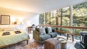 Un dormitorio moderno con una cama grande, un sofá y una chimenea.