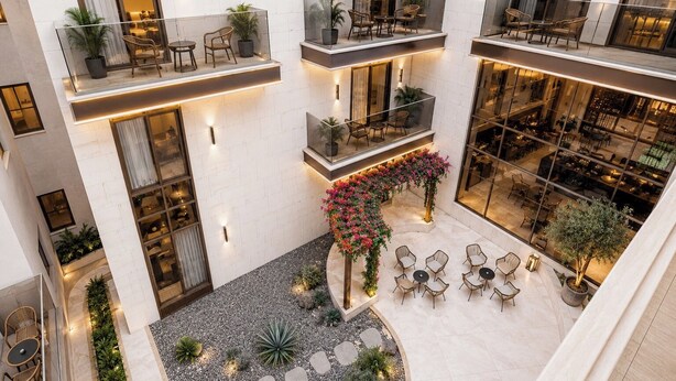 A multi-level atrium with seating areas, potted plants, and a central floral arrangement. - Liora Hotel (Riyadh)