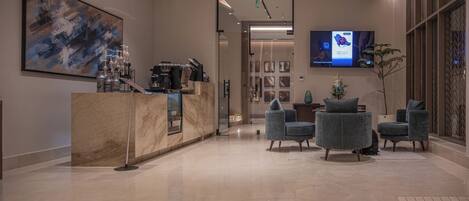 A modern lobby with a reception desk, seating area, and a large abstract painting.