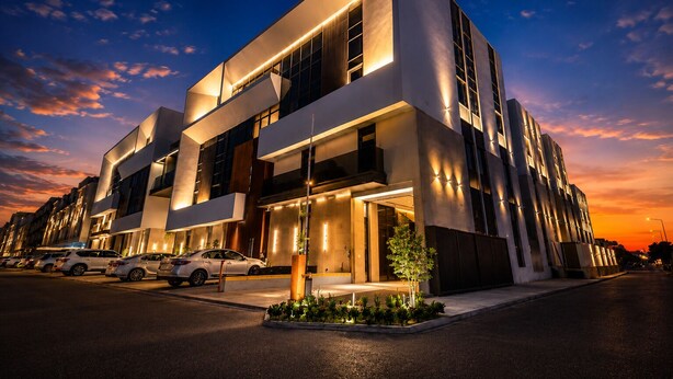 Un hôtel moderne à l’architecture imposante, avec de grandes fenêtres et une entrée bien éclairée.