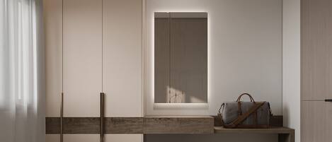 A modern, minimalist room with built-in wardrobes, a small window, a bench, and a blue ottoman.