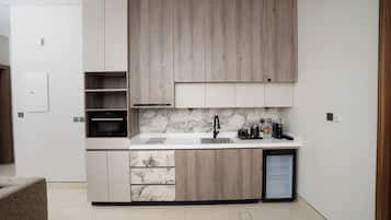 A modern kitchen with a built-in oven, a sink, and a refrigerator.