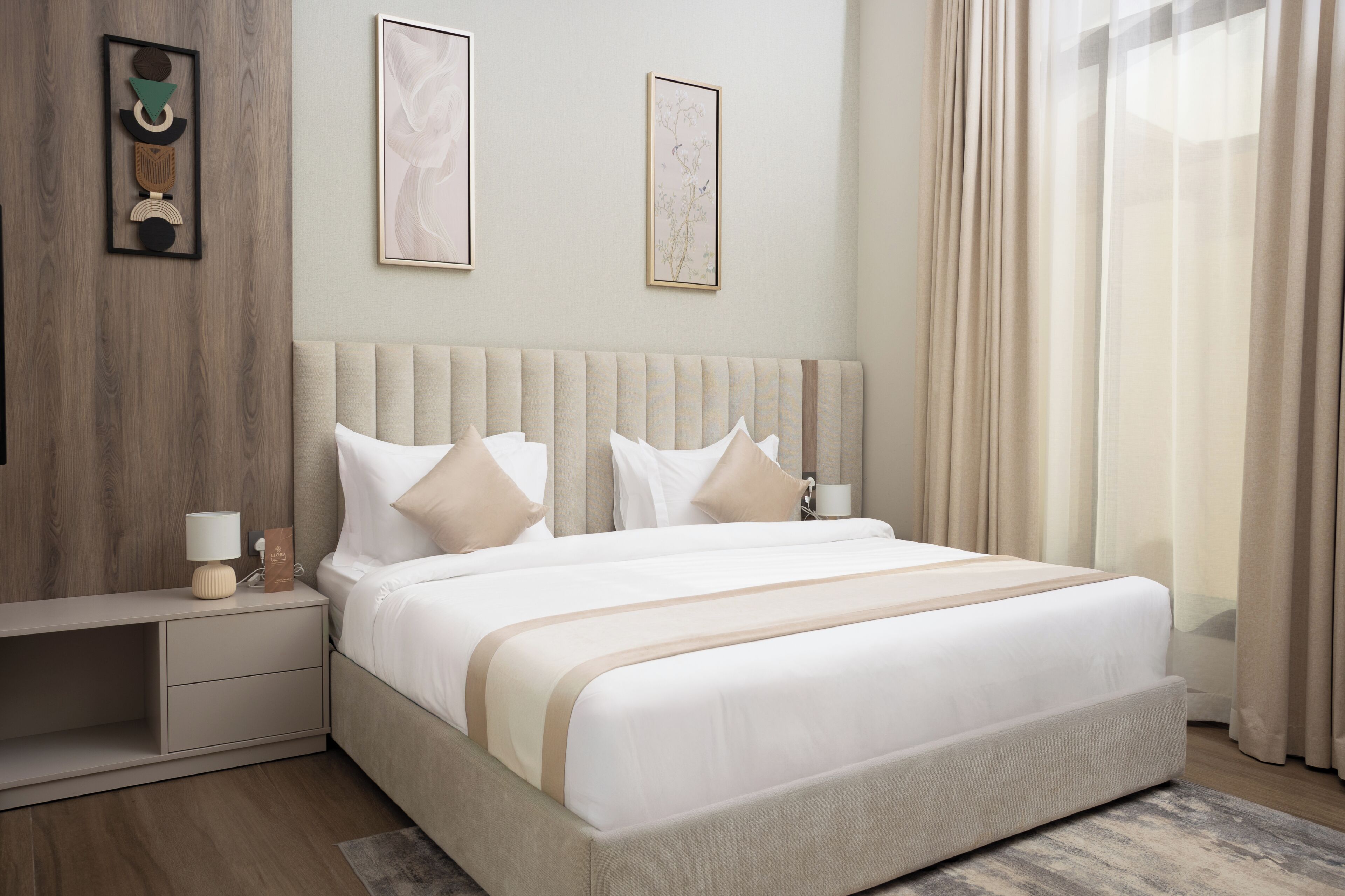 A modern bedroom with a large bed, bedside tables, and wall art.