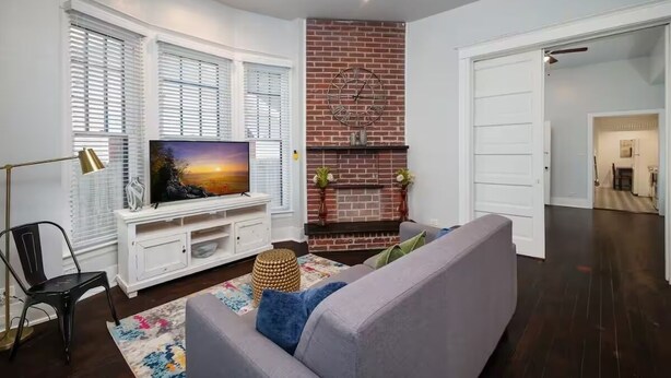 Una sala de estar con chimenea, televisor y sofá.