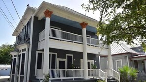 Una casa de dos pisos con balcón, barandillas blancas y el número 118 en la fachada.
