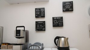 A kitchenette with a coffee maker, kettle, and a wall with coffee and hot drink options. - SUMMER ROOM (Siniscola)