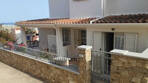 A two-story house with a stone facade, a tiled roof, and a balcony with a metal railing. - SUMMER ROOM (Siniscola)