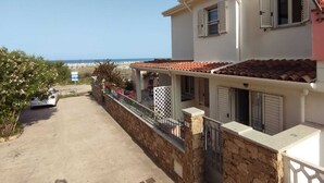 A two-story house with a stone wall and a balcony, overlooking a beach. - SUMMER ROOM (Siniscola)