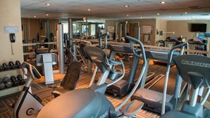 A gym with treadmills, elliptical machines, and free weights.
