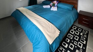 A bedroom with a bed, a nightstand, a window with curtains, and a patterned rug. - Escape to paradise in Paipa, Boyacá in this beautiful Casa Rural San Cipriano!🏡 (Paipa)