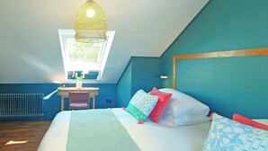 Une chambre à coucher avec un lit, un bureau, une chaise, un radiateur et une fenêtre.