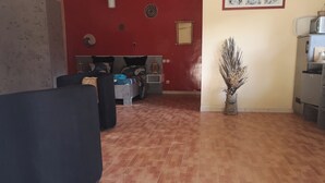 Una sala de estar con un sofá, una cama y un jarrón decorativo.