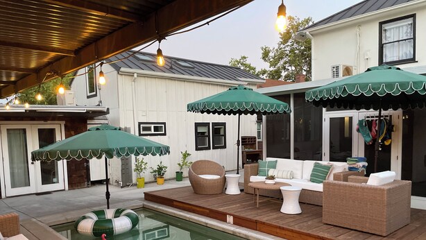A pool area with wicker furniture and green umbrellas. - Curtis Park Charmer! (Sacramento)