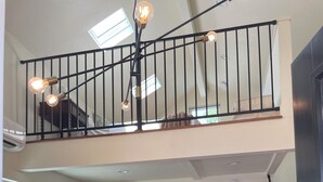 A spacious kitchen with a dining area, a staircase, and a loft with a balcony. - Curtis Park Charmer! (Sacramento)
