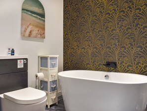 A bathroom with a bathtub, toilet, and a vanity with a mirror. - Classroom One - UK48650 (Lifton)
