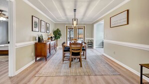 A dining area with a wooden table and chairs, a rug, and a ceiling fan. - Sawgrass Cottage | 3BR with Deck (Columbia)