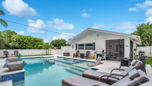 Une maison moderne dotée d’une piscine, de mobilier d’extérieur et d’un espace patio.