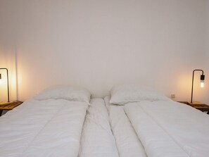 A bed with white bedding, two bedside tables, and two wall-mounted lamps. - 6 Person Holiday Home in Ringkobing (Ringkobing)