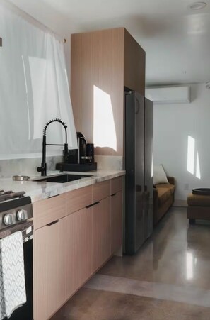 Eine moderne Küche mit Einbauherd, Spüle und Kühlschrank.