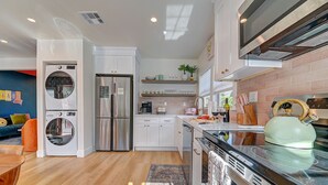 A modern kitchen with a built-in washer, refrigerator, and stove. - Magical Stay Near Disneyland with Pool & Fire Pit (Santa Ana)