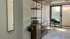 Ein Zimmer mit einem Etagenbett, einem Spiegel, einer Topfpflanze und einem Stuhl.