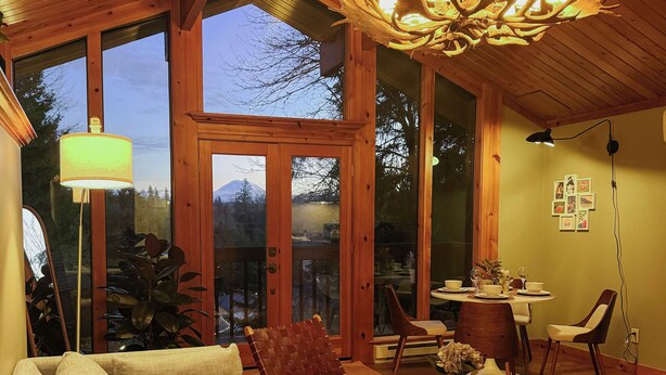 A spacious living area with a wooden ceiling, a large chandelier, and a dining table set for four. - Rainier View Lodge - Mountain View Suite in Scenic Issaquah ｜ Seattle gateaway (Issaquah)