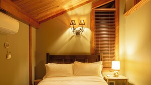 A neatly made bed with a wooden headboard, a wall-mounted light fixture, and a bedside table with a lamp. - Rainier View Lodge - Mountain View Suite in Scenic Issaquah ｜ Seattle gateaway (Issaquah)