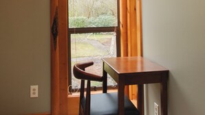 A room with a wooden ceiling, a skylight, a table, and a chair. - Rainier View Lodge - Mountain View Suite in Scenic Issaquah ｜ Seattle gateaway (Issaquah)
