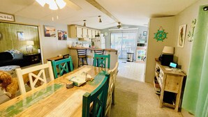A compact kitchen with a dining area, featuring a wooden table, chairs, and a ceiling fan. - Charming 2/2 waterfront farm home with tons of TV stations, WiFi, dock, & more (Spring Hill)