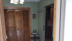 A room with a wooden wardrobe, a small round table with a decorative item, and a sign on the wall. - Charming Country farmhouse (Fredonia)
