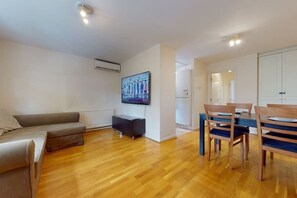 Relax in this stylish living space with a sofa, dining table, and flat-screen TV.