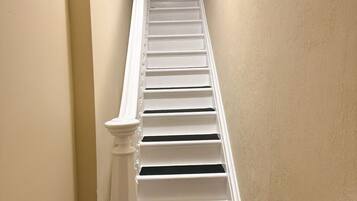 A staircase with white balusters and a beige wall.