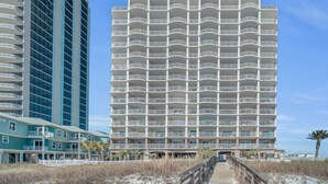 Un hôtel à plusieurs étages, doté de balcons et offrant une vue sur la plage.