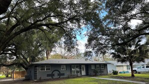 A single-story house with a dark gray exterior, a front porch, and a garage.